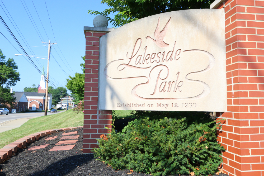 Lakeside Park entrance sign with a bird silhouette, carved script, and brick pillars; notes "Established on May 12, 1930".